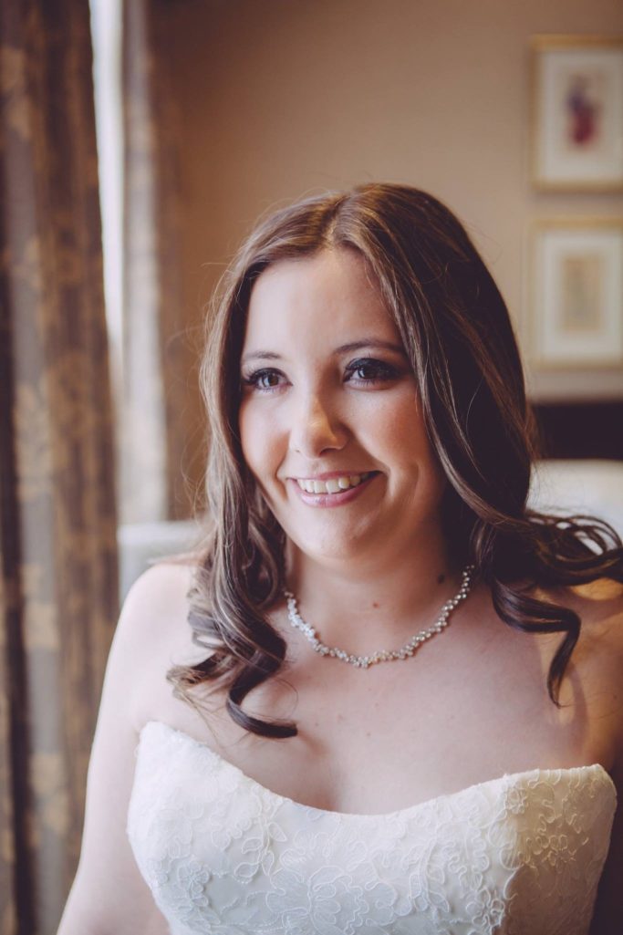 A bride smiling at her Chester Grosvenor wedding morning after her professional makeup application.