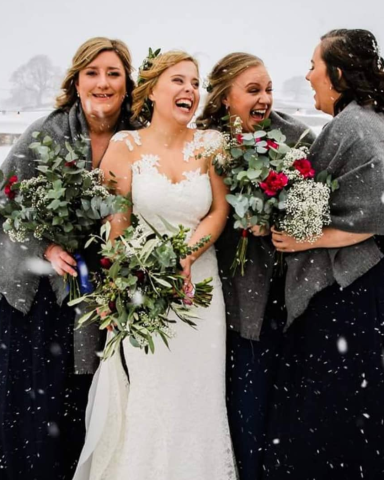 A winter wedding bridal party in the snow, with bridal makeup