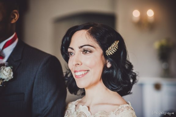 Bride smiling at the altar after her radiant bridal makeup in Rhuthin Castle.