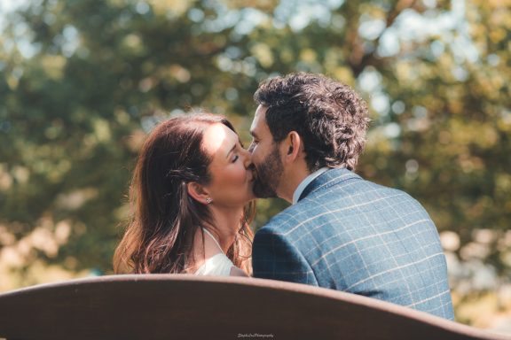 Bride and groom sharing a kiss in Mold after their Registry Office ceremony. The bride has natural makeup