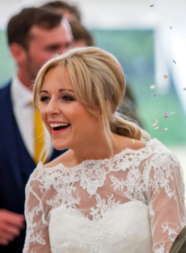 Bride smiling at the camera after her radiant bridal makeup. 
