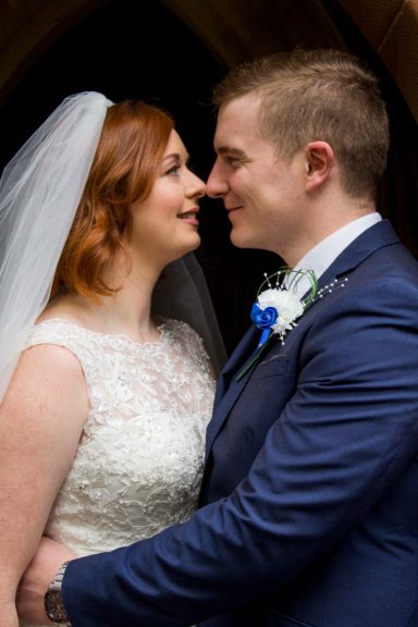 Newlyweds, bride and groom facing each other after their Hawarden ceremony, Flintshire.